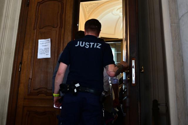 (FILES) A justice officer closes the courtroom's door prior the start of the trial of a palliative care doctor allegedly accused of killing 15 patients with lethal injections, in the Regional Courtroom in Berlin, on July 14, 2025. A German palliative care doctor was sentenced to life in prison by a court in Berlin on July 8, 2026 for murdering 15 people with lethal doses of sedatives. (Photo by Tobias Schwarz / AFP)