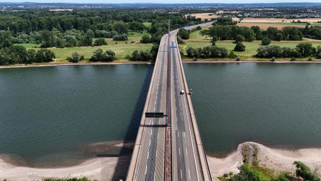 An aerial view shows the closed Bonn North Bridge on the A565 motorway in Bonn, western Germany on July 7, 2026. The dilapidated Bonn North Bridge (Friedrich-Ebert-Brücke) on the A565 has been completely closed to all motor traffic since June 2026. The approach bridge on the left bank of the Rhine has sustained extensive damage, will no longer be opened to traffic, and must be demolished and rebuilt. (Photo by Ina FASSBENDER / AFP)