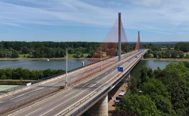 An aerial view shows the closed Bonn North Bridge on the A565 motorway in Bonn, western Germany on July 7, 2026. The dilapidated Bonn North Bridge (Friedrich-Ebert-Brücke) on the A565 has been completely closed to all motor traffic since June 2026. The approach bridge on the left bank of the Rhine has sustained extensive damage, will no longer be opened to traffic, and must be demolished and rebuilt. (Photo by Ina FASSBENDER / AFP)