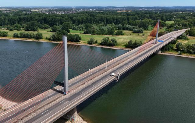 An aerial view shows the closed Bonn North Bridge on the A565 motorway in Bonn, western Germany on July 7, 2026. The dilapidated Bonn North Bridge (Friedrich-Ebert-Brücke) on the A565 has been completely closed to all motor traffic since June 2026. The approach bridge on the left bank of the Rhine has sustained extensive damage, will no longer be opened to traffic, and must be demolished and rebuilt. (Photo by Ina FASSBENDER / AFP)