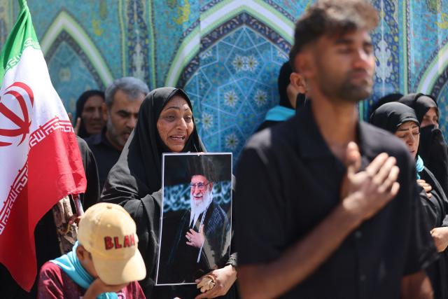 A woman reacts while holding a picture of late Iranian supreme leader Ayatollah Ali Khamenei near the shrine of Imam Hussein in the Iraqi holy city of Karbala on July 8, 2026. Iran began six days of public funeral ceremonies for Khamenei on July 4, including a dedicated day in neighbouring Iraq -- a Shia powerhouse with close ties to Tehran and home to the faith's most sacred shrines. (Photo by AHMAD AL-RUBAYE / AFP)