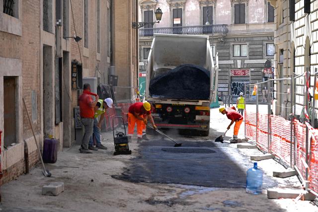 Workers resurface the asphalt of a street under the sun at a construction site in central Rome on July 8, 2026, as parts of Europe experience another heatwave. (Photo by Andreas SOLARO / AFP)
