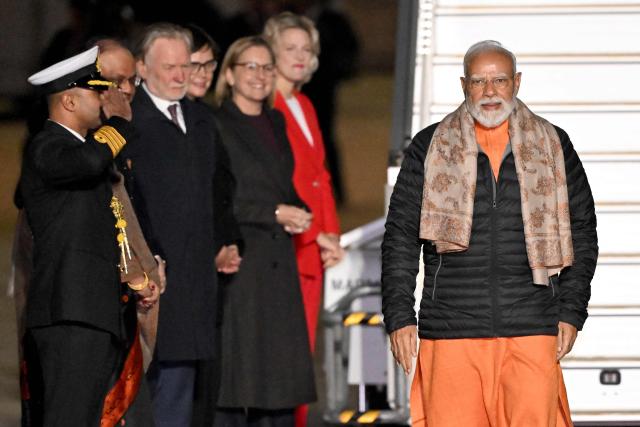 Indian Prime Minister Narendra Modi (R) walks past dignitaries assembled to welcome him upon his arrival at Melbourne International Airport in Melbourne on July 8, 2026, at the start of an official visit to Australia. (Photo by WILLIAM WEST / AFP)