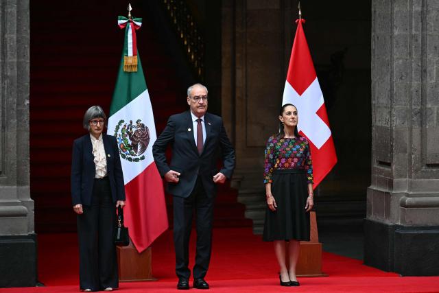 Mexico's President Claudia Sheinbaum (R) poses with Guy Parmelin (C), President of the Swiss Confederation and Minister of Economy, and his wife, Caroline Merotto, at National Palace in Mexico City on July 8, 2026. (Photo by YURI CORTEZ / AFP)