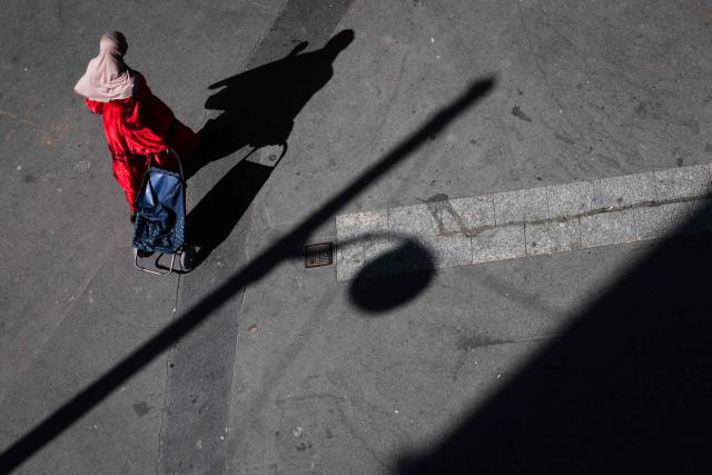 A woman walks in Paris on July 8, 2026. (Photo by JOEL SAGET / AFP)