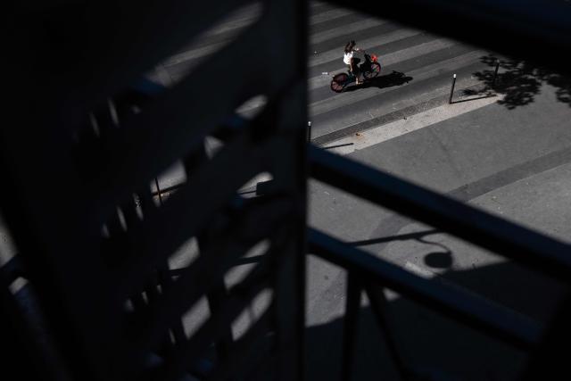 A cyclist rides in Paris on July 8, 2026, as France experiences a heatwave. (Photo by JOEL SAGET / AFP)