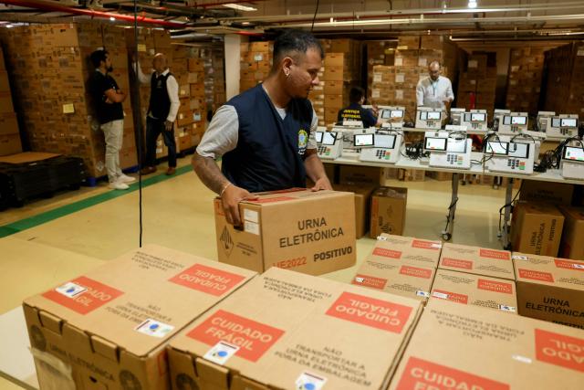A staff member of the Amazonas Regional Electoral Court (TRE/AM) arranges boxes containing electronic voting machines during testing preparations in Manaus, Amazonas state, Brazil, on July 8, 2026. (Photo by MICHAEL DANTAS / AFP)