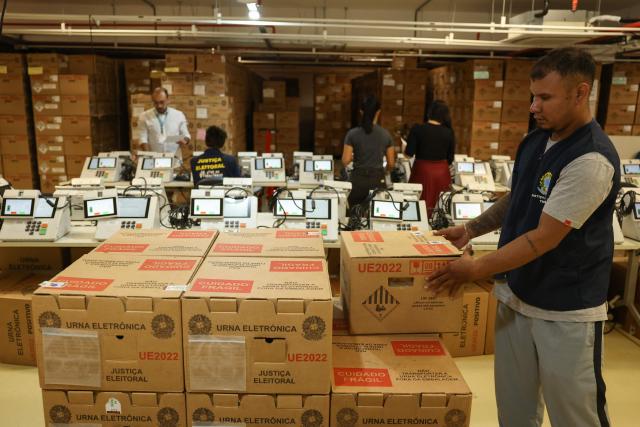 A staff member of the Amazonas Regional Electoral Court (TRE/AM) arranges boxes containing electronic voting machines during testing preparations in Manaus, Amazonas state, Brazil, on July 8, 2026. (Photo by MICHAEL DANTAS / AFP)