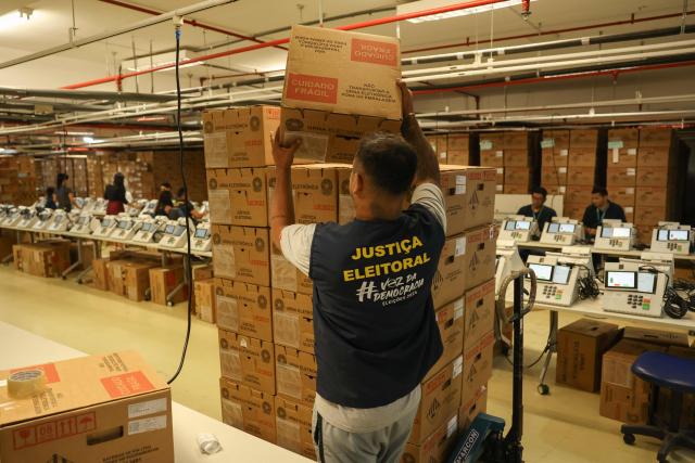 A staff member of the Amazonas Regional Electoral Court (TRE/AM) arranges boxes containing electronic voting machines during testing preparations in Manaus, Amazonas state, Brazil, on July 8, 2026. (Photo by MICHAEL DANTAS / AFP)
