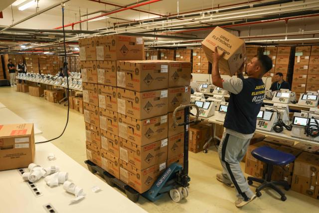 A staff member of the Amazonas Regional Electoral Court (TRE/AM) arranges boxes containing electronic voting machines during testing preparations in Manaus, Amazonas state, Brazil, on July 8, 2026. (Photo by MICHAEL DANTAS / AFP)