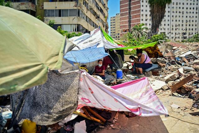 Families camp on top of the ruins of a building as they wait for the recovery of the corpses of their relatives, in Caraballeda, La Guaira state, Venezuela, on July 8, 2026, after the June 24 earthquakes. Venezuela's government called on July 8, 2026 for the release of frozen assets to help raise funds for the country's recovery from last month's twin earthquakes that killed at least 3,600 people. (Photo by MARTIN BERNETTI / AFP)