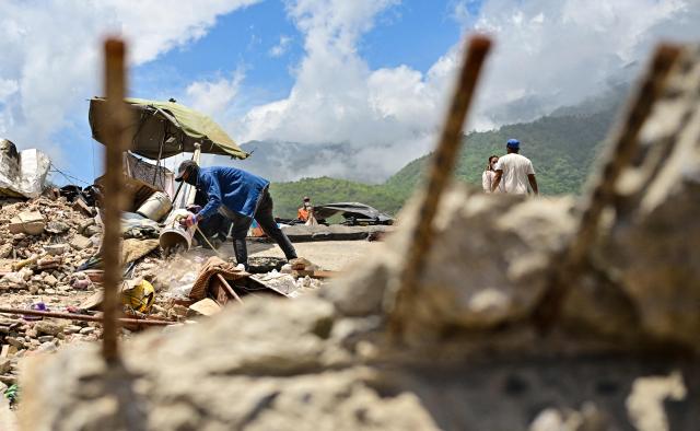 Venezuelan rescue workers search for victims in a destroyed building in Caraballeda, La Guaira state, Venezuela, on July 8, 2026, after the June 24 earthquakes. Venezuela's government called on July 8, 2026 for the release of frozen assets to help raise funds for the country's recovery from last month's twin earthquakes that killed at least 3,600 people. (Photo by MARTIN BERNETTI / AFP)
