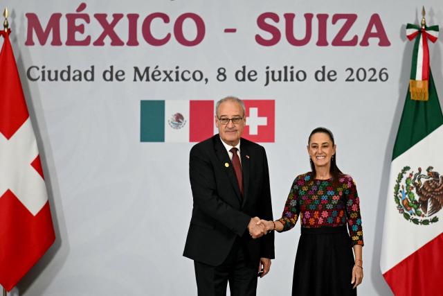 Switzerland's President of the Confederation and Economy Minister Guy Parmelin (L) and Mexico's President Claudia Sheinbaum shake hands at the end of a press conference at the National Palace in Mexico City on July 8, 2026. (Photo by YURI CORTEZ / AFP)