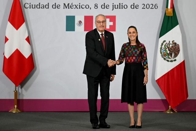Switzerland's President of the Confederation and Economy Minister Guy Parmelin and Mexico's President Claudia Sheinbaum shake hands at the end of a press conference at the National Palace in Mexico City on July 8, 2026. (Photo by YURI CORTEZ / AFP)