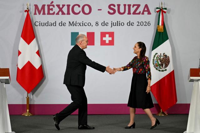 Switzerland's President of the Confederation and Economy Minister Guy Parmelin (L) and Mexico's President Claudia Sheinbaum shake hands at the end of a press conference at the National Palace in Mexico City on July 8, 2026. (Photo by YURI CORTEZ / AFP)