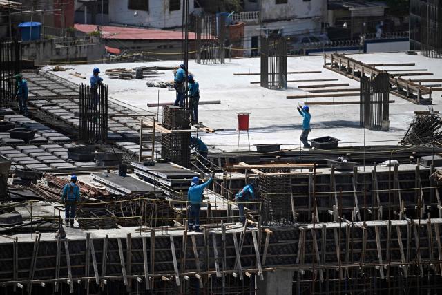 Men work at a construction site in Maiquetia, Venezuela, on July 8, 2026. Venezuela's government called on July 8, 2026 for the release of frozen assets to help raise funds for the country's recovery from last month's twin earthquakes that killed at least 3,600 people. (Photo by Federico PARRA / AFP)