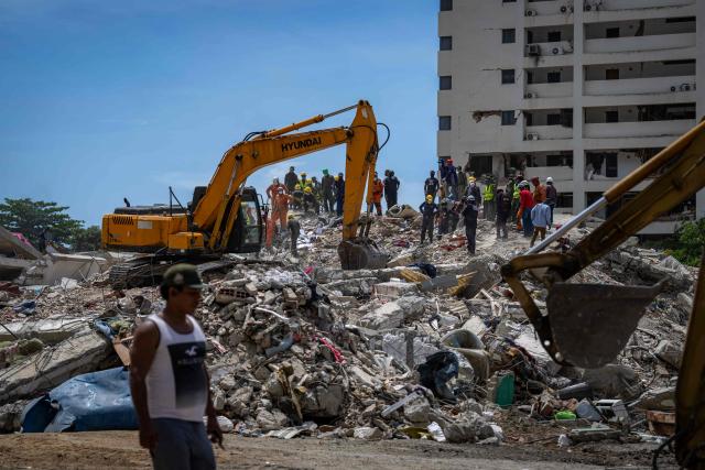 Heavy machinery, rescuers and volunteers are seen on a destroyed building in Taraguarena, in the state of La Guaira, Venezuela, on July 8, 2026. Venezuela's government called on July 8, 2026 for the release of frozen assets to help raise funds for the country's recovery from last month's twin earthquakes that killed at least 3,600 people. (Photo by Miguel MEDINA / AFP)