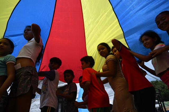 Children play at a temporary shelter site in the Cesar Nieves baseball stadium in the La Angustia neighborhood of Catia La Mar, La Guaira state, Venezuela, on July 8, 2026, following powerful earthquakes that struck the region. Venezuela's government called on July 8, 2026 for the release of frozen assets to help raise funds for the country's recovery from last month's twin earthquakes that killed at least 3,600 people. (Photo by Raul ARBOLEDA / AFP)