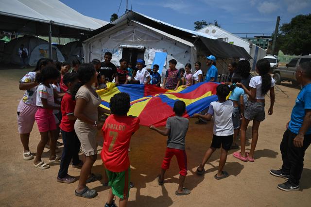 Children play at a temporary shelter site in the Cesar Nieves baseball stadium in the La Angustia neighborhood of Catia La Mar, La Guaira state, Venezuela, on July 8, 2026, following powerful earthquakes that struck the region. Venezuela's government called on July 8, 2026 for the release of frozen assets to help raise funds for the country's recovery from last month's twin earthquakes that killed at least 3,600 people. (Photo by Raul ARBOLEDA / AFP)