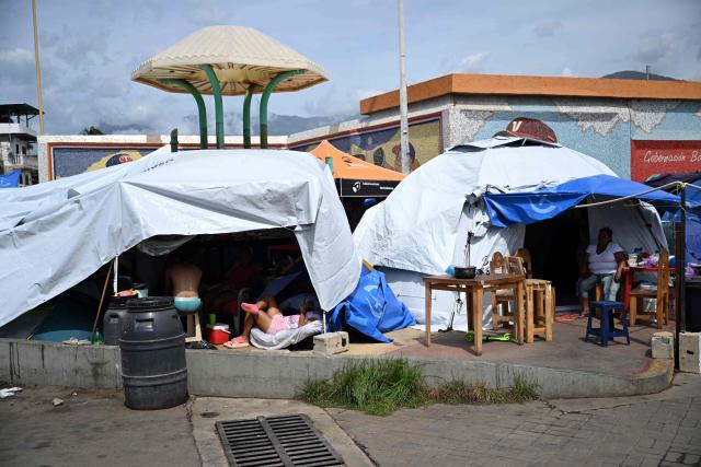 Displaced people take shelter outside the Cesar Nieves baseball stadium in the La Angustia neighborhood of Catia La Mar, La Guaira state, Venezuela, on July 8, 2026, following powerful earthquakes that struck the region. Venezuela's government called on July 8, 2026 for the release of frozen assets to help raise funds for the country's recovery from last month's twin earthquakes that killed at least 3,600 people. (Photo by Raul ARBOLEDA / AFP)