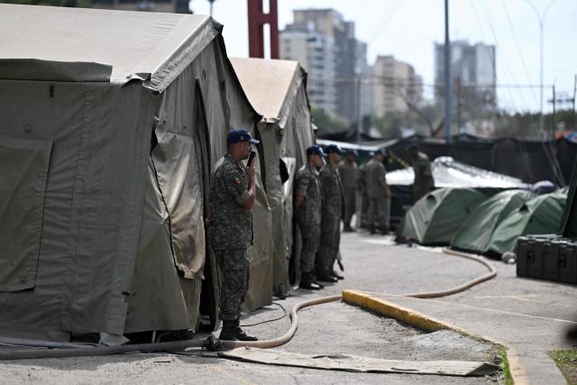 Members of the Brazilian Navy stand outside the emergency hospital set up following the June 24 earthquakes in Caraballeda, La Guaira state, Venezuela on July 8, 2026. Venezuela's government called on July 8, 2026 for the release of frozen assets to help raise funds for the country's recovery from last month's twin earthquakes that killed at least 3,600 people. (Photo by Juan BARRETO / AFP)