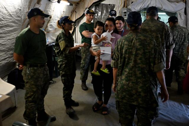 Brazilian Navy personnel receive people seeking medical attention at an emergency hospital in Caraballeda, La Guaira state, Venezuela, on July 8, 2026, following powerful earthquakes that struck the region. Venezuela's government called on July 8, 2026 for the release of frozen assets to help raise funds for the country's recovery from last month's twin earthquakes that killed at least 3,600 people. (Photo by Juan BARRETO / AFP)