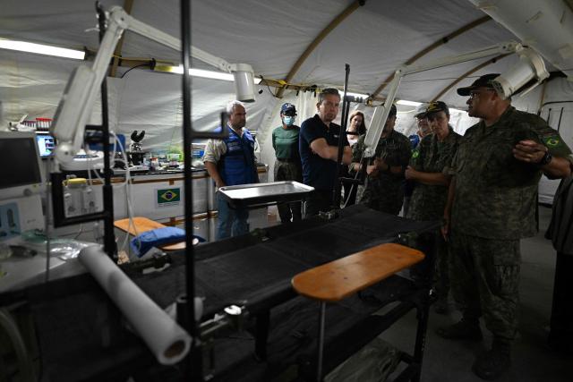 United Nations Under-Secretary-General for Humanitarian Affairs and Emergency Relief Coordinator Tom Fletcher (3rd L) visits an emergency hospital set up by members of the Brazilian Navy following the June 24 earthquakes in Caraballeda, La Guaira state, Venezuela on July 8, 2026. Venezuela's government called on July 8, 2026 for the release of frozen assets to help raise funds for the country's recovery from last month's twin earthquakes that killed at least 3,600 people. (Photo by Juan BARRETO / AFP)
