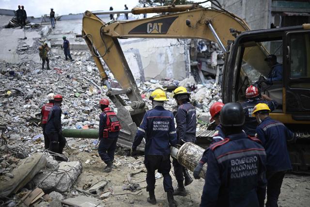 Firefighters work amid the rubble of collapsed buildings following the June 24 earthquakes in Catia La Mar, La Guaira state, Venezuela on July 8, 2026. Venezuela's government called on July 8, 2026 for the release of frozen assets to help raise funds for the country's recovery from last month's twin earthquakes that killed at least 3,600 people. (Photo by Federico PARRA / AFP)