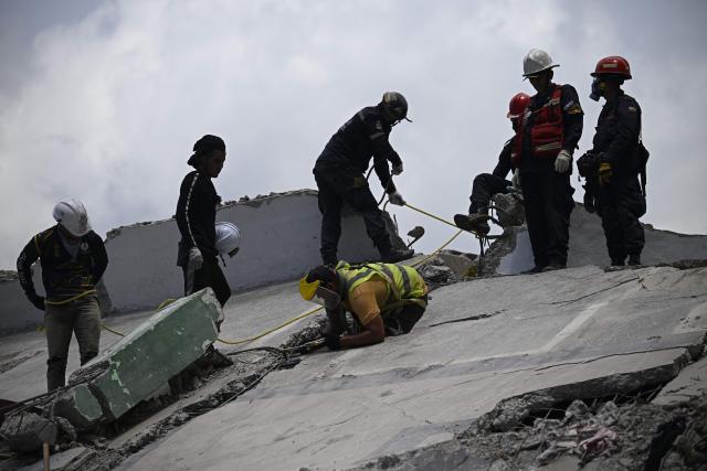 Firefighters and rescue workers operate amid the rubble of collapsed buildings following the June 24 earthquakes in Catia La Mar, La Guaira state, Venezuela on July 8, 2026. Venezuela's government called on July 8, 2026 for the release of frozen assets to help raise funds for the country's recovery from last month's twin earthquakes that killed at least 3,600 people. (Photo by Federico PARRA / AFP)