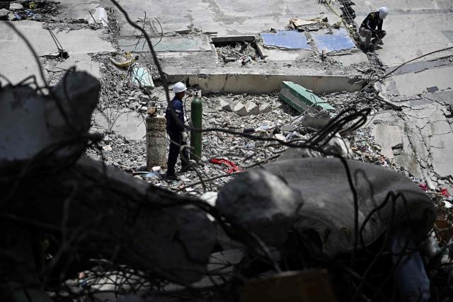 Rescue workers operate amid the rubble of collapsed buildings following the June 24 earthquakes in Catia La Mar, La Guaira state, Venezuela on July 8, 2026. Venezuela's government called on July 8, 2026 for the release of frozen assets to help raise funds for the country's recovery from last month's twin earthquakes that killed at least 3,600 people. (Photo by Federico PARRA / AFP)