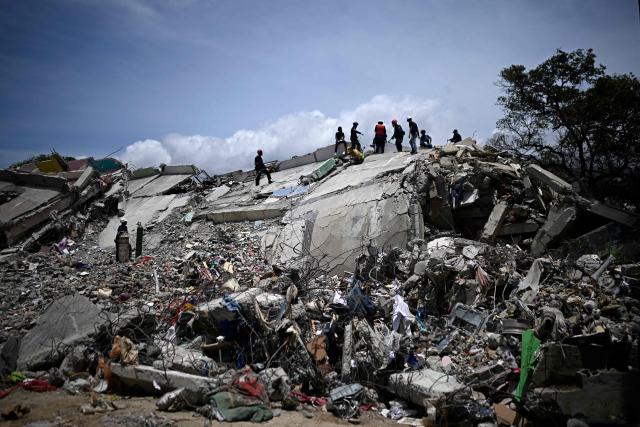 Firefighters and rescue workers operate amid the rubble of collapsed buildings following the June 24 earthquakes in Catia La Mar, La Guaira state, Venezuela on July 8, 2026. Venezuela's government called on July 8, 2026 for the release of frozen assets to help raise funds for the country's recovery from last month's twin earthquakes that killed at least 3,600 people. (Photo by Federico PARRA / AFP)