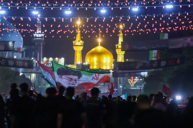 Mourners arrive to attend the funeral of slain Iranian leader Ali Khamenei and members of his family near Imam Reza's shrine in Mashhad early on July 9, 2026. Iranians were preparing on July 9 to bury their slain leader Ali Khamenei in his hometown of Mashhad in northeast Iran, as new US strikes threatened to trigger a fresh escalation in the Middle East war. The late supreme leader's burial follows a multi-day funeral ceremony that attracted millions of mourners across various cities in both Iran and Iraq. (Photo by ATTA KENARE / AFP) / 