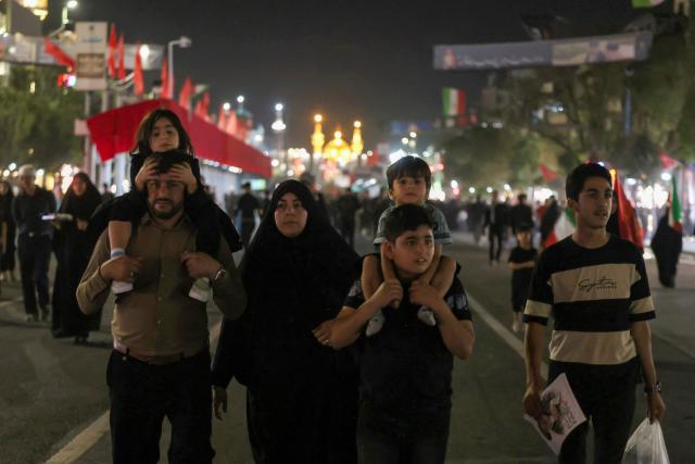 People walk along a street as they arrive to attend the funeral of slain Iranian leader Ali Khamenei and members of his family near Imam Reza's shrine in Mashhad early on July 9, 2026. Iranians were preparing on July 9 to bury their slain leader Ali Khamenei in his hometown of Mashhad in northeast Iran, as new US strikes threatened to trigger a fresh escalation in the Middle East war. The late supreme leader's burial follows a multi-day funeral ceremony that attracted millions of mourners across various cities in both Iran and Iraq. (Photo by ATTA KENARE / AFP) / 