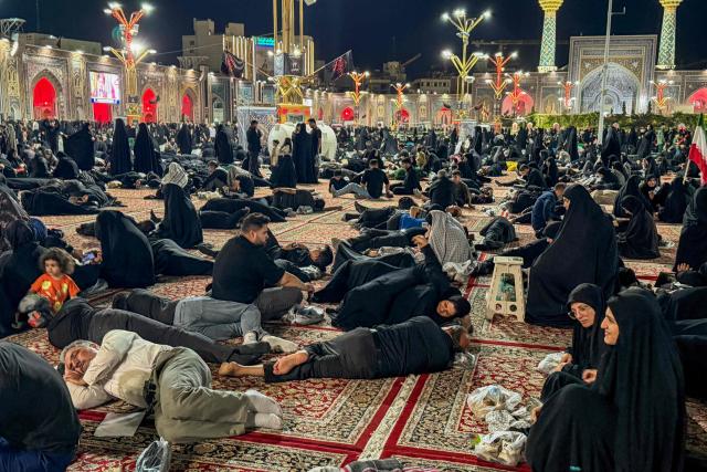 People wait at Imam Reza's shrine for the funeral of slain Iranian leader Ali Khamenei and members of his family in Mashhad early on July 9, 2026. Iranians were preparing on July 9 to bury their slain leader Ali Khamenei in his hometown of Mashhad in northeast Iran, as new US strikes threatened to trigger a fresh escalation in the Middle East war. The late supreme leader's burial follows a multi-day funeral ceremony that attracted millions of mourners across various cities in both Iran and Iraq. (Photo by ATTA KENARE / AFP) / 