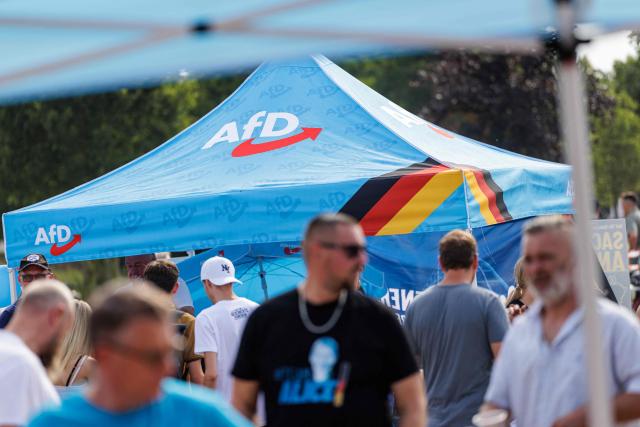 Participants attend an election campaign event of the far-right Alternative for Germany (AfD) party's and a motorbike and moped ride in Jessnitz, eastern Germany on June 28, 2026. Fans of far-right Alternative for Germany party's top candidate for the regional elections in Saxony-Anhalt, Ulrich Siegmund joined him for a countryside ride on Simson-brand scooters, that have become a symbol of East German identity. Descendants of the Simson firm's namesake Jewish founders, who gave up the company to escape persecution in Nazi Germany, have denounced the AfD's appropriation of the brand name. (Photo by Jens SCHLÜTER / AFP)