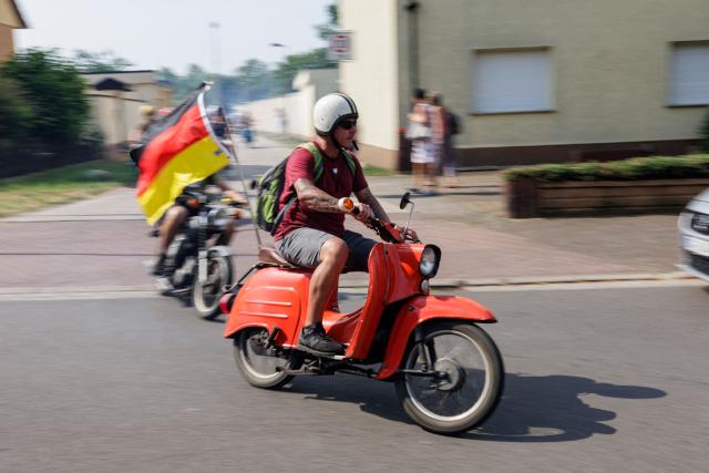 A man rides a Simson moped during an election campaign event of the far-right Alternative for Germany (AfD) party's and a motorbike and moped ride in Jessnitz, eastern Germany on June 28, 2026. Fans of far-right Alternative for Germany party's top candidate for the regional elections in Saxony-Anhalt, Ulrich Siegmund joined him for a countryside ride on Simson-brand scooters, that have become a symbol of East German identity. Descendants of the Simson firm's namesake Jewish founders, who gave up the company to escape persecution in Nazi Germany, have denounced the AfD's appropriation of the brand name. (Photo by Jens SCHLÜTER / AFP)