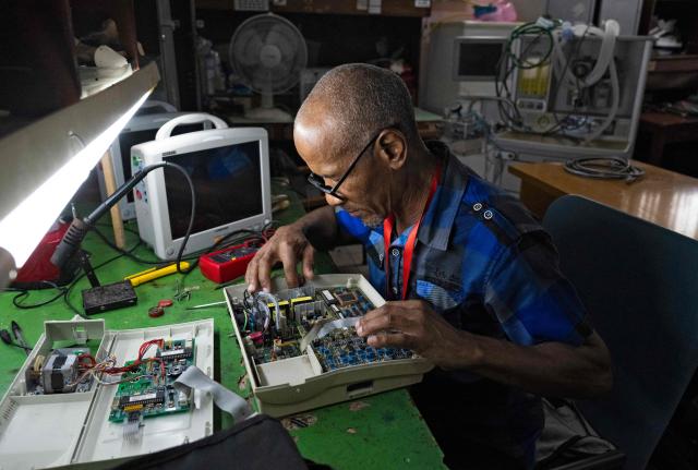 Luis Alexis Duncan, a specialist in electromedicine, is working in the Electromedicine Workshop at the Institute of Cardiology and Cardiovascular Surgery in Havana on July 1, 2026. In the midst of one of the worst economic crises Cuba has experienced in decades, the health system is striving to maintain its services and priority programmes despite medicine and supply shortages, technological deterioration, staff shortages, prolonged power cuts and the impact of the United States sanctions. (Photo by YAMIL LAGE / AFP)