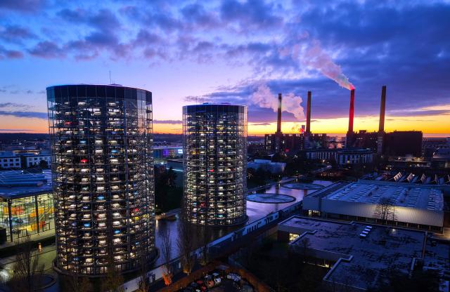 (FILES) An aerial view shows the illuminated tower storage facility (L) and the power plant of German carmaker Volkswagen (VW) at the company's headquarters in Wolfsburg, central Germany, at dusk on November 21, 2025. German auto giant Volkswagen's management meet on July 9, 2026 to thrash out plans for what could be the biggest ever restructuring in the global auto industry with unions set to protest any mass job cuts. (Photo by Ronny HARTMANN / AFP)