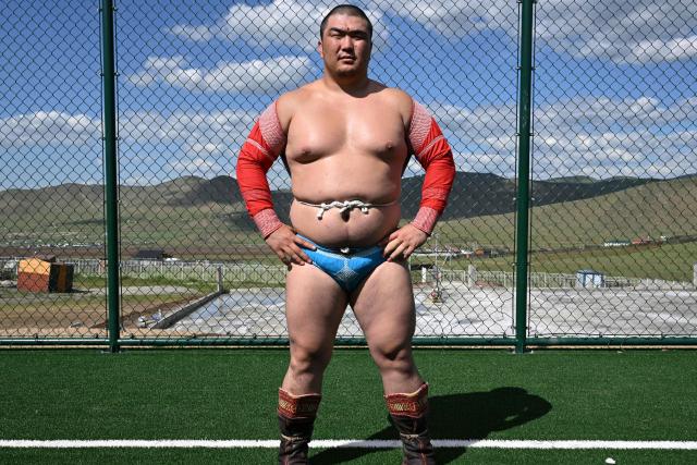 This photo taken on June 24, 2026 shows a Mongolian wrestler posing at a training camp ahead of the Naadam Festival on the outskirts of Ulaanbaatar. The whistle blows, sending dozens of hulking wrestlers chasing a football in the Mongolian grasslands -- a World Cup twist in their gruelling training for one of the country's oldest sporting traditions. (Photo by Adek BERRY / AFP) / To go with 'MONGOLIA-LIFESTYLE-TRADITION-WRESTLING,FOCUS' by Mungunsor Purevsuren