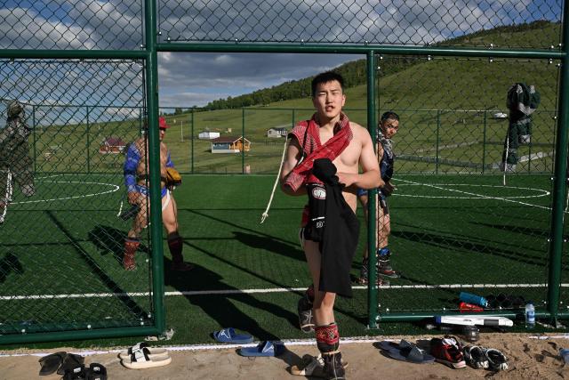 This photo taken on June 24, 2026 shows Mongolian wrestlers leaving a field following a session at a training camp ahead of the Naadam Festival on the outskirts of Ulaanbaatar. The whistle blows, sending dozens of hulking wrestlers chasing a football in the Mongolian grasslands -- a World Cup twist in their gruelling training for one of the country's oldest sporting traditions. (Photo by Adek BERRY / AFP) / To go with 'MONGOLIA-LIFESTYLE-TRADITION-WRESTLING,FOCUS' by Mungunsor Purevsuren