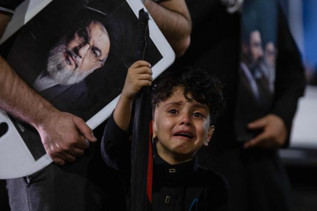 A child cries during the funeral procession of Iran's late supreme leader Ayatollah Ali Khamenei near the shrine of Imam Hussein in the Iraqi holy city of Karbala, on July 9, 2026. Iranians were preparing on July 9 to bury their slain leader Ali Khamenei in his hometown of Mashhad in northeast Iran, as new US strikes threatened to trigger a fresh escalation in the Middle East war. The late leader's burial follows a multi-day funeral ceremony that attracted millions of mourners across various cities in both Iran and Iraq. (Photo by murtadha ridha / AFP)