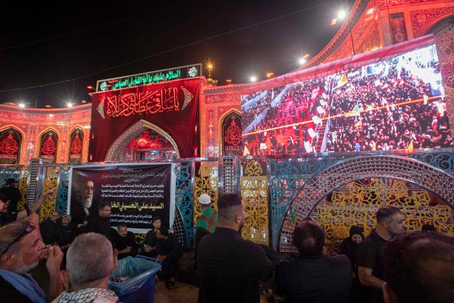 Mourners watch the live broadcast of the funeral procession of Iran's late supreme leader Ayatollah Ali Khamenei near Imam Abbas Shrine in Karbala, Iraq, early on July 9, 2026. Iranians were preparing on July 9 to bury their slain leader Ali Khamenei in his hometown of Mashhad in northeast Iran, as new US strikes threatened to trigger a fresh escalation in the Middle East war. The late leader's burial follows a multi-day funeral ceremony that attracted millions of mourners across various cities in both Iran and Iraq. (Photo by murtadha ridha / AFP)