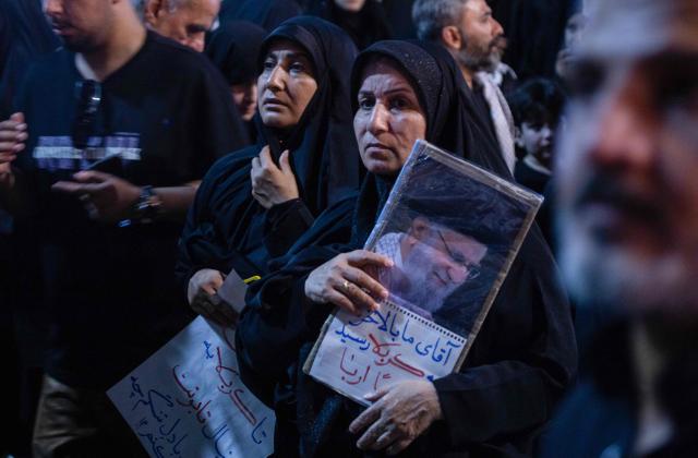 A woman holds a picture of the late Iranian supreme leader Ayatollah Ali Khamenei near the shrine of Imam Hussein in the Iraqi holy city of Karbala, on July 9, 2026. Iranians were preparing on July 9 to bury their slain leader Ali Khamenei in his hometown of Mashhad in northeast Iran, as new US strikes threatened to trigger a fresh escalation in the Middle East war. The late leader's burial follows a multi-day funeral ceremony that attracted millions of mourners across various cities in both Iran and Iraq. (Photo by murtadha ridha / AFP)