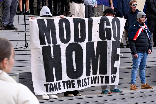 Anti-immigration protesters hold a banner outside the venue for a community event with Indian Prime Minister Narendra Modi at Docklands Stadium in Melbourne on July 9, 2026. (Photo by WILLIAM WEST / AFP)