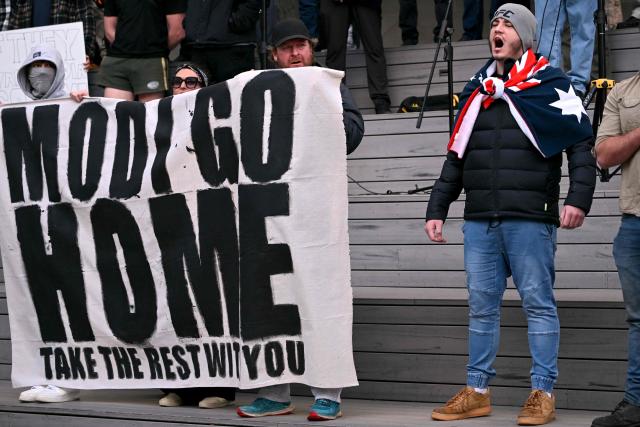 Anti-immigration protesters chant slogans and hold a banner outside the venue for a community event with Indian Prime Minister Narendra Modi at Docklands Stadium in Melbourne on July 9, 2026. (Photo by WILLIAM WEST / AFP)