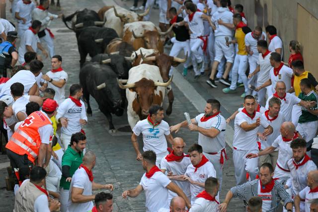 Participants run ahead of bulls from the Victoriano del Rio bull ranch during the third running of the bulls of the San Fermin festival in Pamplona, northern Spain, on July 9, 2026. Thousands of people every year attend the week-long festival and its famous 'encierros', or running of the bulls, in which six bulls are released at 8:00 a.m. evey day to run from their corral to the bullring through the narrow streets of the old town over an 850 meters (yards) course while runners ahead of them try to stay close to the bulls without falling over or being gored. (Photo by JORGE GUERRERO / AFP)