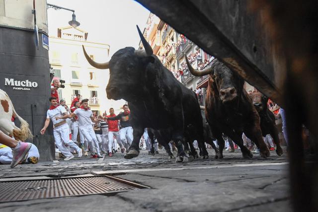 Bulls from the Victoriano del Rio bull ranch run through the Mercaderes curve during the third running of the bulls of the San Fermin festival in Pamplona, northern Spain, on July 9, 2026. Thousands of people every year attend the week-long festival and its famous 'encierros', or running of the bulls, in which six bulls are released at 8:00 a.m. evey day to run from their corral to the bullring through the narrow streets of the old town over an 850 meters (yards) course while runners ahead of them try to stay close to the bulls without falling over or being gored. (Photo by ANDER GILLENEA / AFP)
