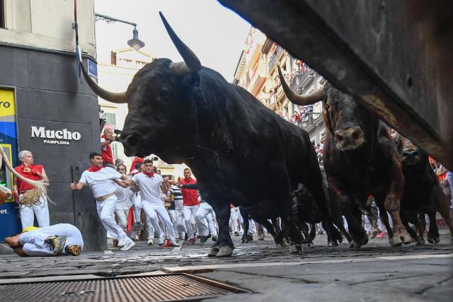 Bulls from the Victoriano del Rio bull ranch run through the Mercaderes curve during the third running of the bulls of the San Fermin festival in Pamplona, northern Spain, on July 9, 2026. Thousands of people every year attend the week-long festival and its famous 'encierros', or running of the bulls, in which six bulls are released at 8:00 a.m. evey day to run from their corral to the bullring through the narrow streets of the old town over an 850 meters (yards) course while runners ahead of them try to stay close to the bulls without falling over or being gored. (Photo by ANDER GILLENEA / AFP)