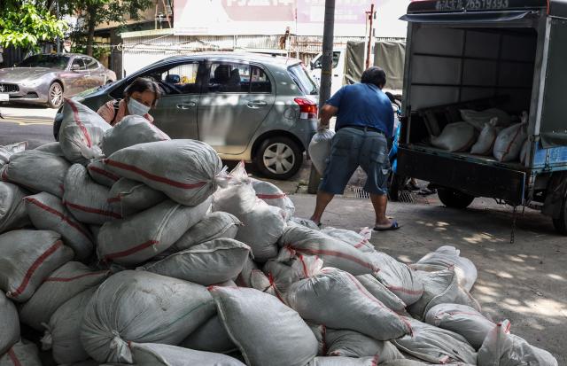 People load sandbags onto a truck as preparations are made ahead of the arrival of Typhoon Bavi, in Taipei on July 9, 2026 (Photo by I-Hwa Cheng / AFP)