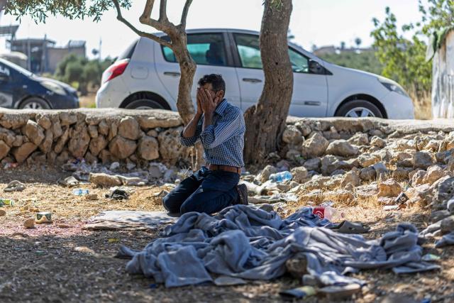 A Palestinian man offers prayers beside a pile of prisoner's clothes while waiting for his relative to be released from Israeli prison at the checkpoint on the outskirts of Israeli occupied West Bank city of Ramallah on July 8, 2026. The number of Palestinian detainees in Israeli prisons stands at around 9,500, according to figures released in June by the Palestinian Prisoners Club, the main rights group for Palestinian prisoners. Since the start of the Gaza war in October 2023, violence has escalated in the Israeli-occupied West Bank. (Photo by ilia YEFIMOVICH / AFP)